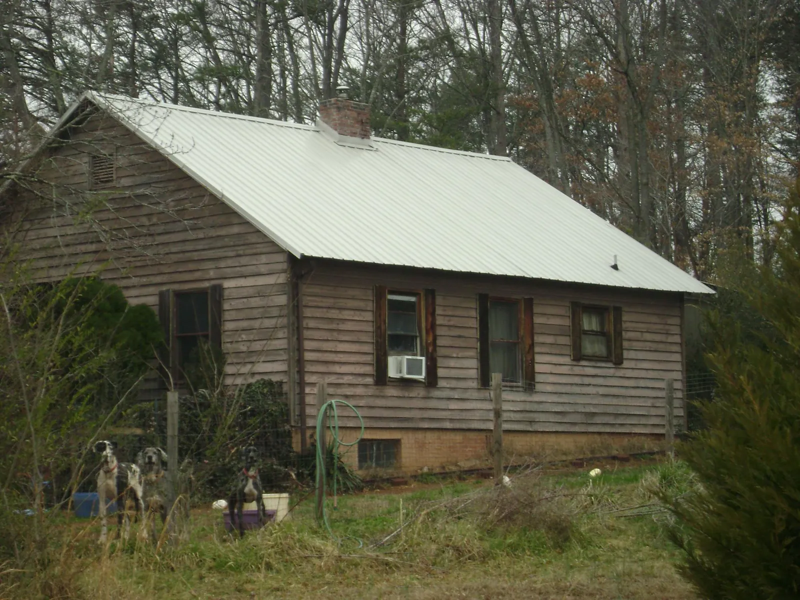 White metal roof on an old wood sided farmhouse, from a Metal Roof Installation job in Sherman